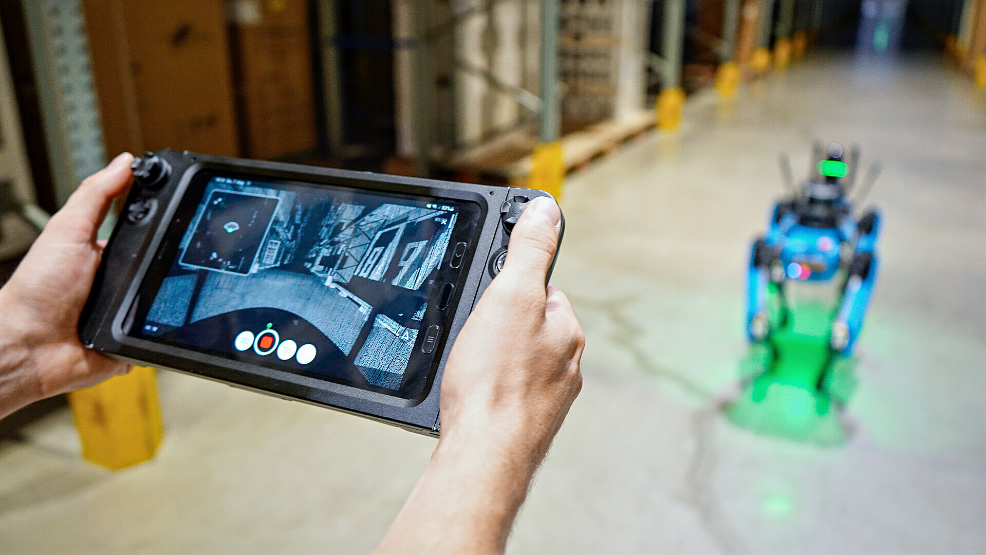 Person hält ein Tablet mit einer Steuerungsapp für einen Roboter