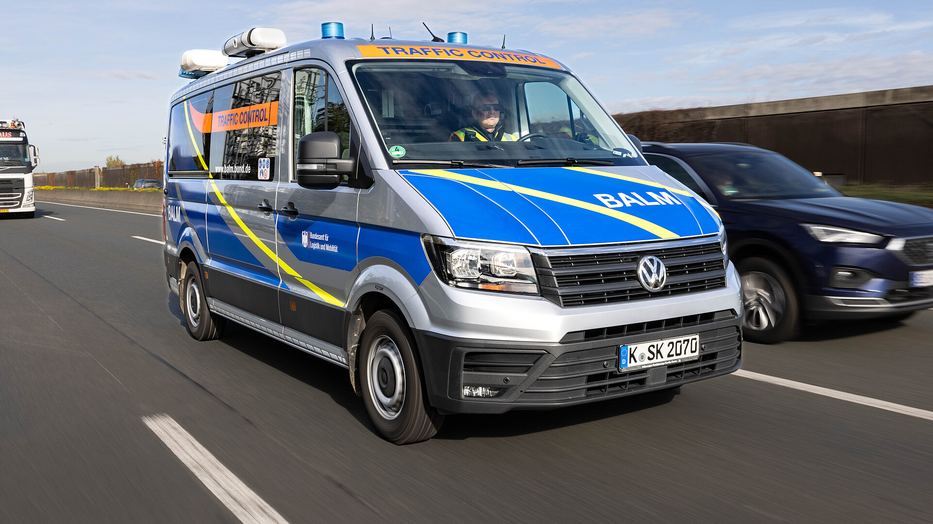 Eine blaue und silberne Volkswagen-Dienstwagen fährt auf einer Straße