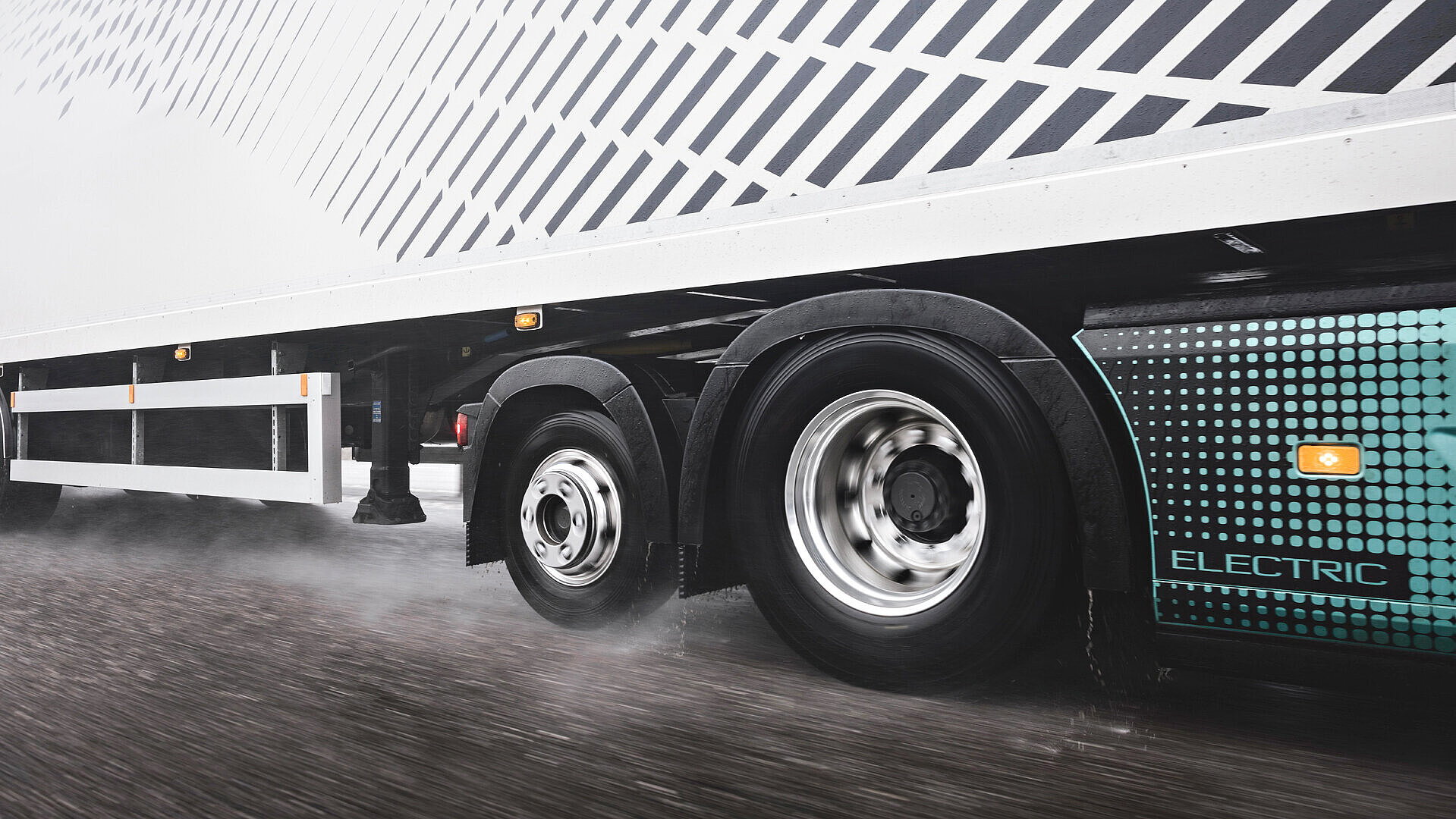 Ein elektrischer LKW fährt auf einer nassen Straße